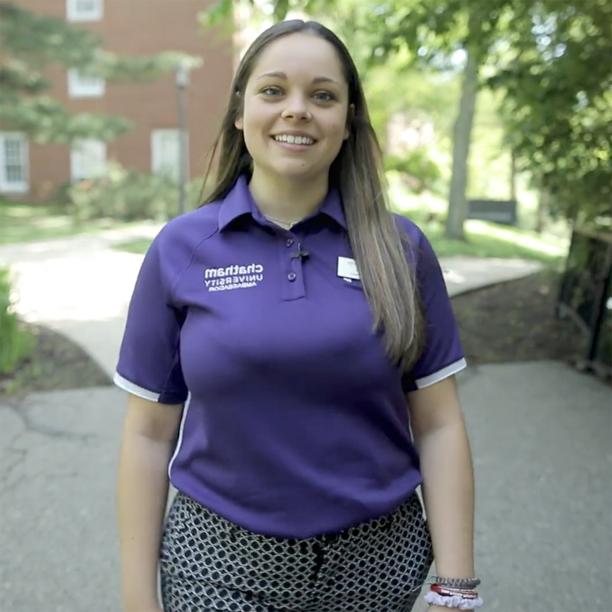 Photo of a Chatham University 学生 in a bright purple polo shirt, smiling